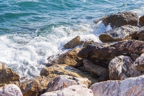 Fototapeta Naklejka Na Ścianę i Meble -  Coastal foamy waves crashing on the rocks on the Athens promenade