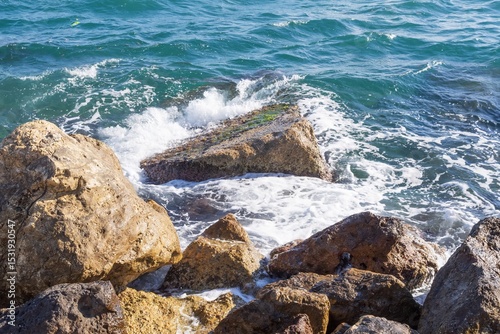 Fototapeta Naklejka Na Ścianę i Meble -  Coastal foamy waves crashing on the rocks on the Athens promenade
