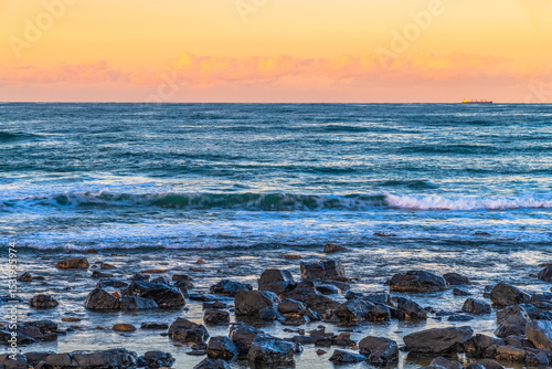 Sunset at the Seaside with black rocks photo