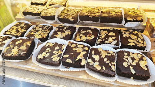 Chocolate Brownie Display: An array of decadent chocolate brownies, generously topped with sliced nut, tempting passersby with rich aroma and fudgy texture.