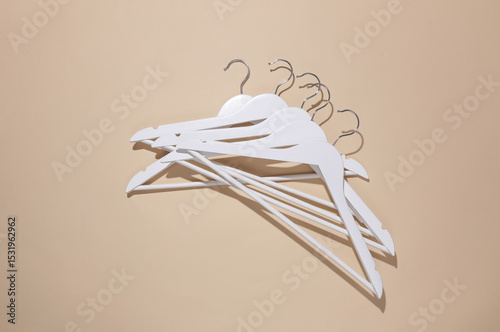 White wooden hanger on beige background. Top view. Flat lay photo