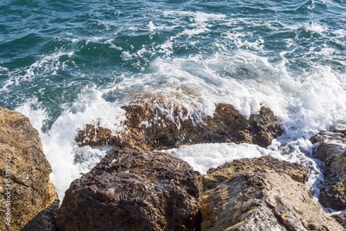 Fototapeta Naklejka Na Ścianę i Meble -  Coastal foamy waves crashing on the rocks on the Athens promenade