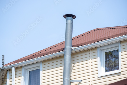 A chimney on a house with a roof photo