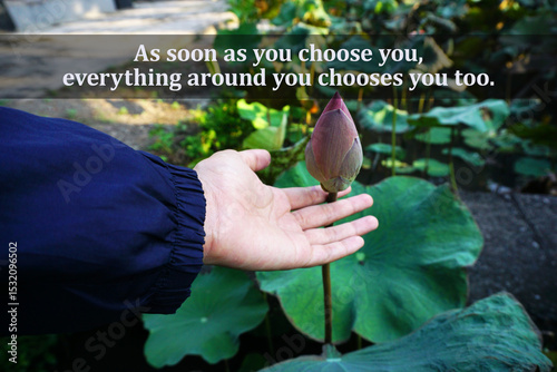 Inspirational motivational quote - As soon as you choose you, everything around you choose you. With person holding bud of pink lotus flower in hand in the garden. Self love care. Believe in yourself.