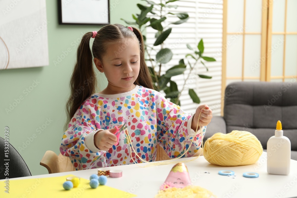 Little girl making craft at white table indoors. Child creativity Little girl making craft at white table indoors. Child creativity