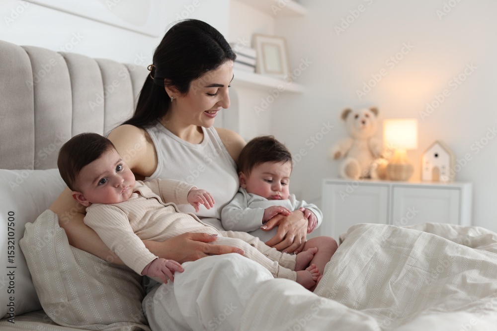 Bedtime. Mother with her cute little babies on bed at home Bedtime. Mother with her cute little babies on bed at home