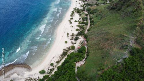 Scenic aerial view of idyllic white sandy beach and mangroves with waves on coastline of Dili, Timor-Leste