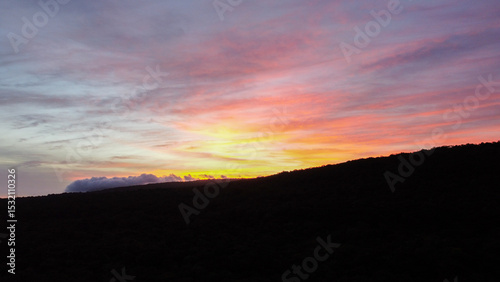Aerial view of beautiful sunset over silhouetted hill landscape on tropical island of Timor-Leste, Southeast Asia 