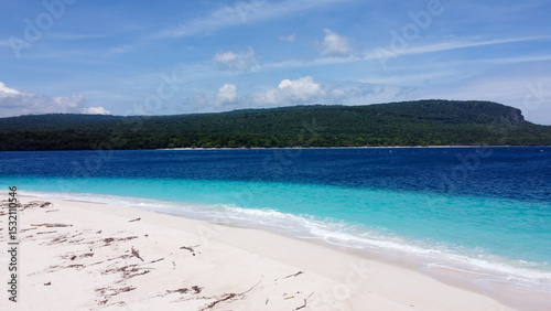 Scenic view from Jaco Island in Timor-Leste looking across turquoise ocean water towards mainland from white sandy beach