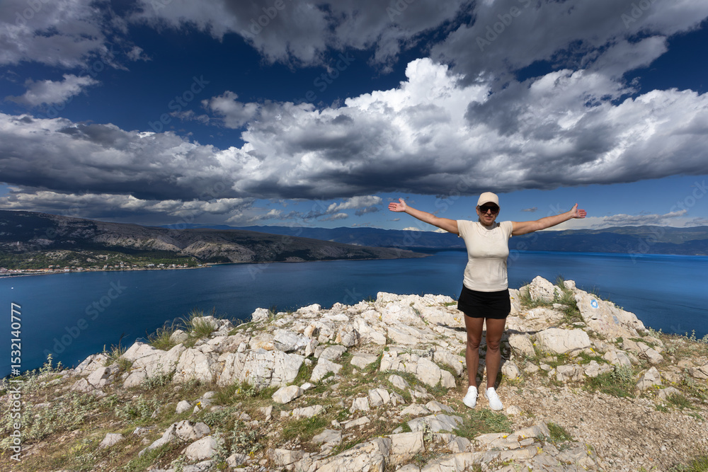 Obraz premium Climbing the Bag peak on the island of KRK, a view of the panorama of the city of Baska, sharp rocks,