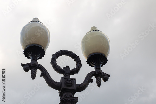 A street light stands under a cloudy sky in the background above