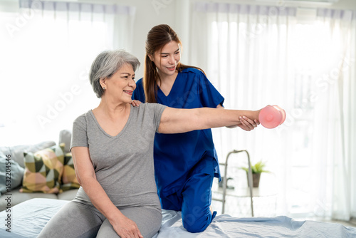 Asian senior mature woman doing physiotherapist with support from nurse.
