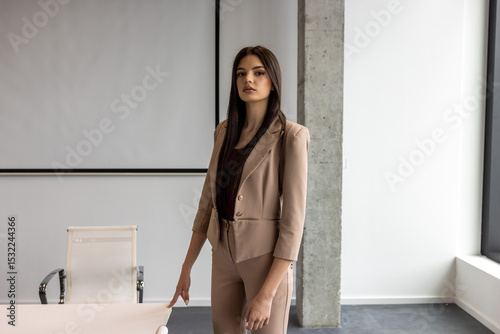 Young businesswoman in a suit posing in an office photo