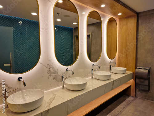 Contemporary interior of public toilet with sinks and mirrors