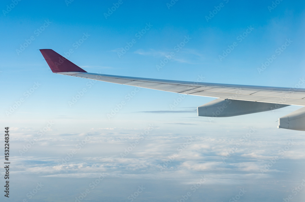 Fototapeta premium The wing of an airplane on the background of clouds in flight. A clear day