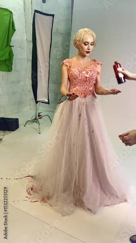 Stunning model in elegant gown poses for creative photoshoot with paint