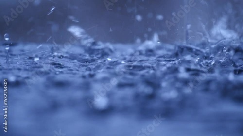 Raindrops fall into submerged roads, and road flooding occurs due to heavy rain in the wet season. Autumn rain falls into a large puddle on the asphalt.