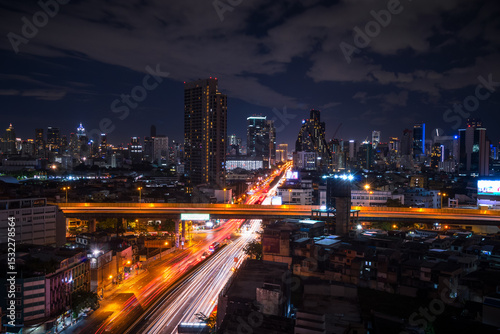 Bangkok city skyline at night with light trails on expressway, long exposure urban view in Thailand
