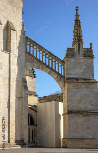 The Cathedrale Saint-Andre features a gothic flying buttress with an ornate balustrade, connecting two parts of the cathedral structure. Bordeaux. France