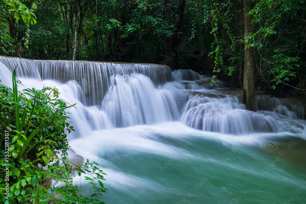 Obraz premium Serene tropical waterfall surrounded by lush green forest, Huay Mae Khamin National Park, Kanchanaburi, Thailand