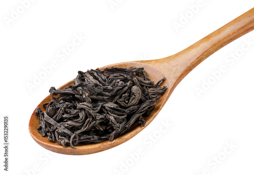 Dry black tea leaves in a wooden spoon close-up on a white. Isolated