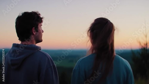 Two friends admiring sunset over vast landscape in peaceful moment