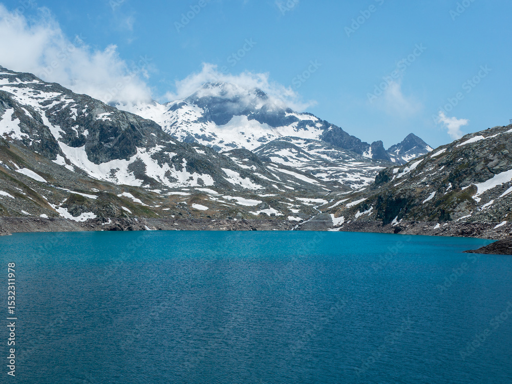 Obraz premium Turquoise Lake and Snowy Peaks in Belledonne Massif – Lac des 7 Laux, French Alps