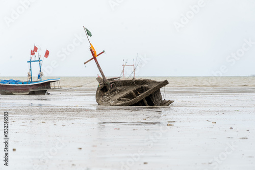 Fototapeta Naklejka Na Ścianę i Meble -  A boat is on the beach with a green flag on it