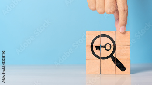 Finding solutions concept. Business problem solving and make decision. New ideas and innovation. Team brainstorming to set strategies. Hand holds wooden cubes with magnifying glass and key icon
