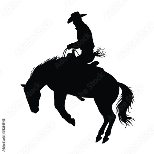 Silhouette of cowboy riding bucking bronco