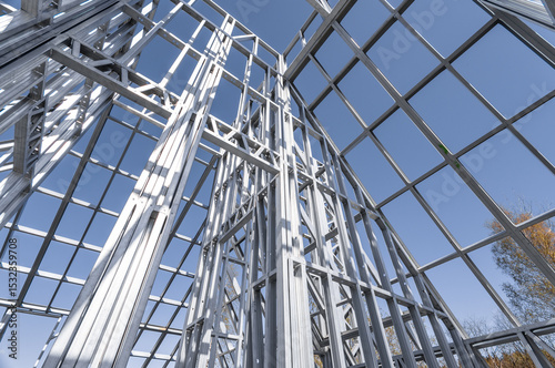 Building in construction, Metallic structure against a clear sky. New residential construction home metal framing.