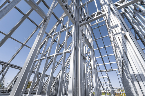 Building in construction, Metallic structure against a clear sky. New residential construction home metal framing.
