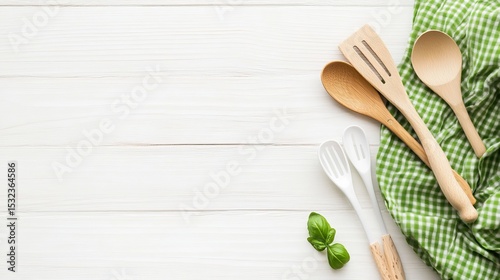 Fototapeta Naklejka Na Ścianę i Meble -  A white wooden table has a green cloth and cooking tools on it. This is a top-down view. You can easily add your product or text to the empty cloth area.
