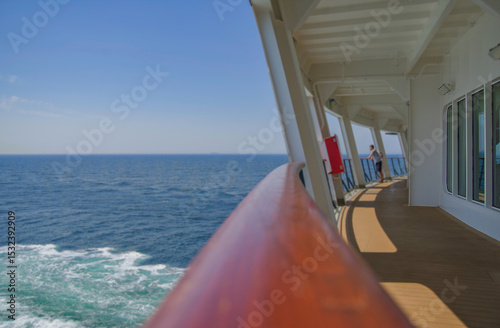 Outdoor promenade boat sun deck onboard modern luxury cruiseship cruise ship ocean liner with teak wood loungers and deck chairs for guests passengers with ocean view