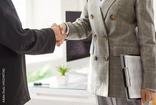 Cropped image of unknown business people making hand shake gesture symbolizing successful agreement or partnership, posing in office setting, reaching culmination of effective teamwork