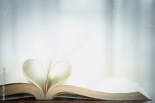 Open book with heart-shaped pages. Concept of romance, love of reading, literature passion, storytelling, and emotional connection through books.
