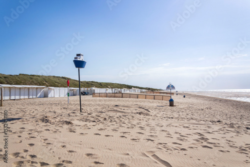 Wooden model of a blue and white boat on pole on a sandy beach, coastal village De Haan, West Flanders, Belgium