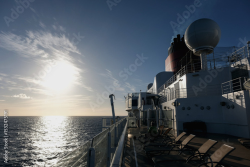 Outdoor promenade boat sun deck onboard modern luxury cruiseship cruise ship ocean liner with teak wood loungers and deck chairs for guests passengers with ocean views