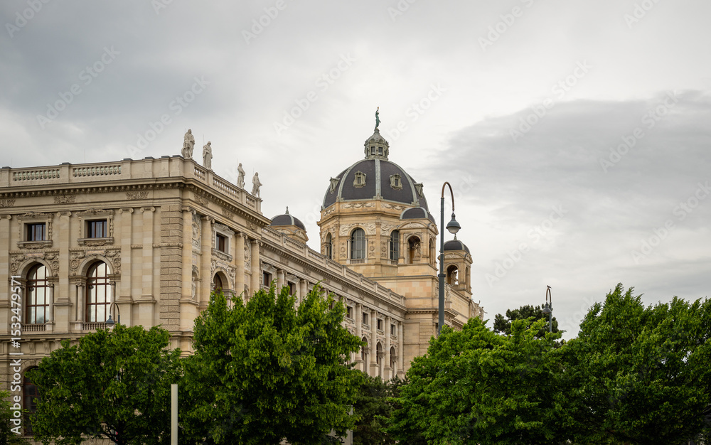 Obraz premium Historic European building with dome and statues under cloudy sky in springtime