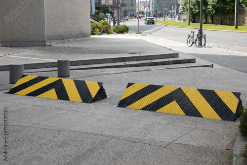 car retractable roadblock obstacle entering the ground and rising against vehicles trying to enter a site yellow road sign photo