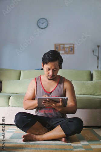 Man Using Tablet for Fitness or Study at Home in a Relaxed Setting