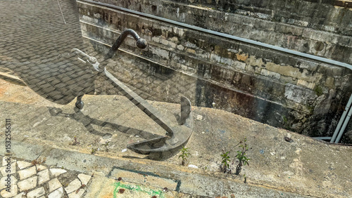 Rusty anchor rests on cobblestones, whispering forgotten maritime tales, capturing Time Travel Days melancholic essence and oceanic nostalgia