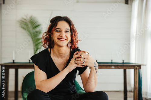 Woman laughing while holding a coffee mug