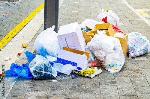 Pile of garbage on the footpath at side road in big city, pollution trash,Korea