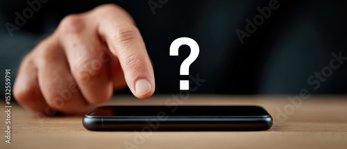 Using a smartphone to ask questions close-up of a male user holding a phone with query symbols on screen at a desk blurred background for technology concept