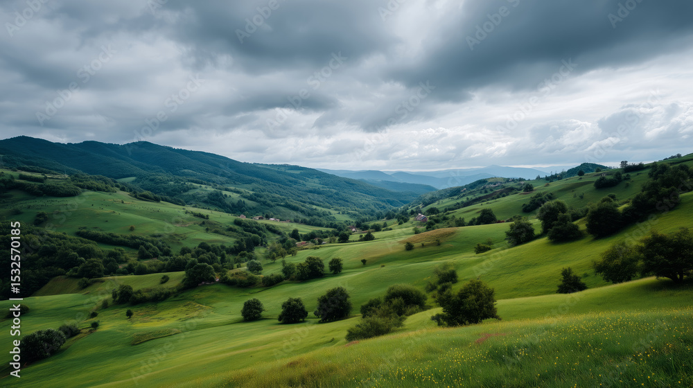 Fototapeta premium Rolling green hills under a cloudy gray sky in a tranquil landscape