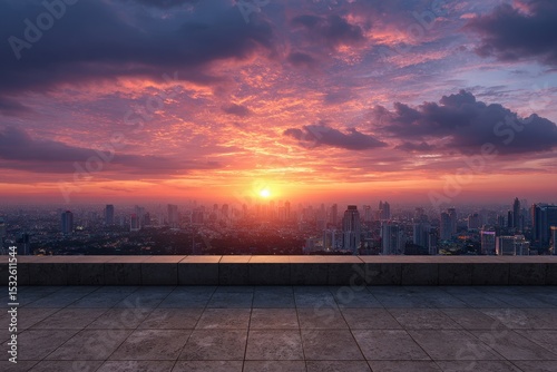 Cityscape view from rooftop at sunset with vibrant clouds and horizon glow scene