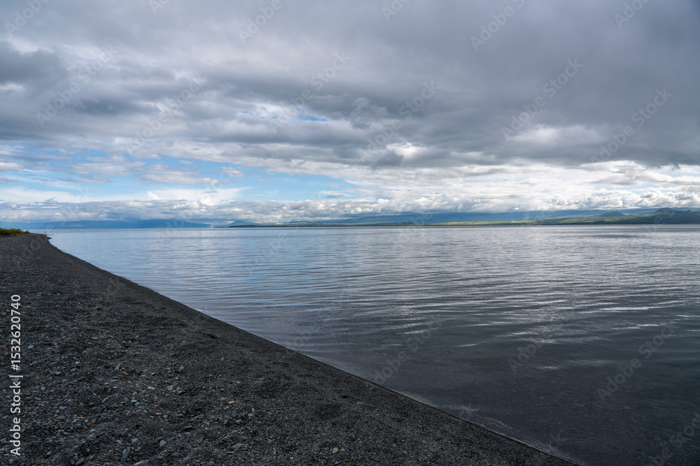 Obraz premium Dramatic Clouds Over a Calm Mountain Lake