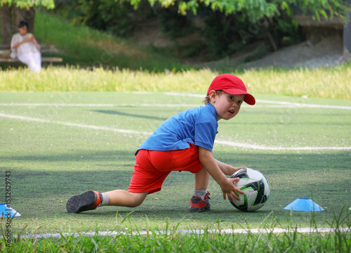  little three-year-old boy plays football at a sports school.
