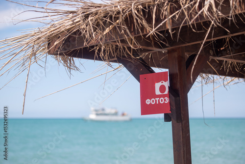 Fototapeta Naklejka Na Ścianę i Meble -  A red sign with a camera on it is hanging from a wooden post